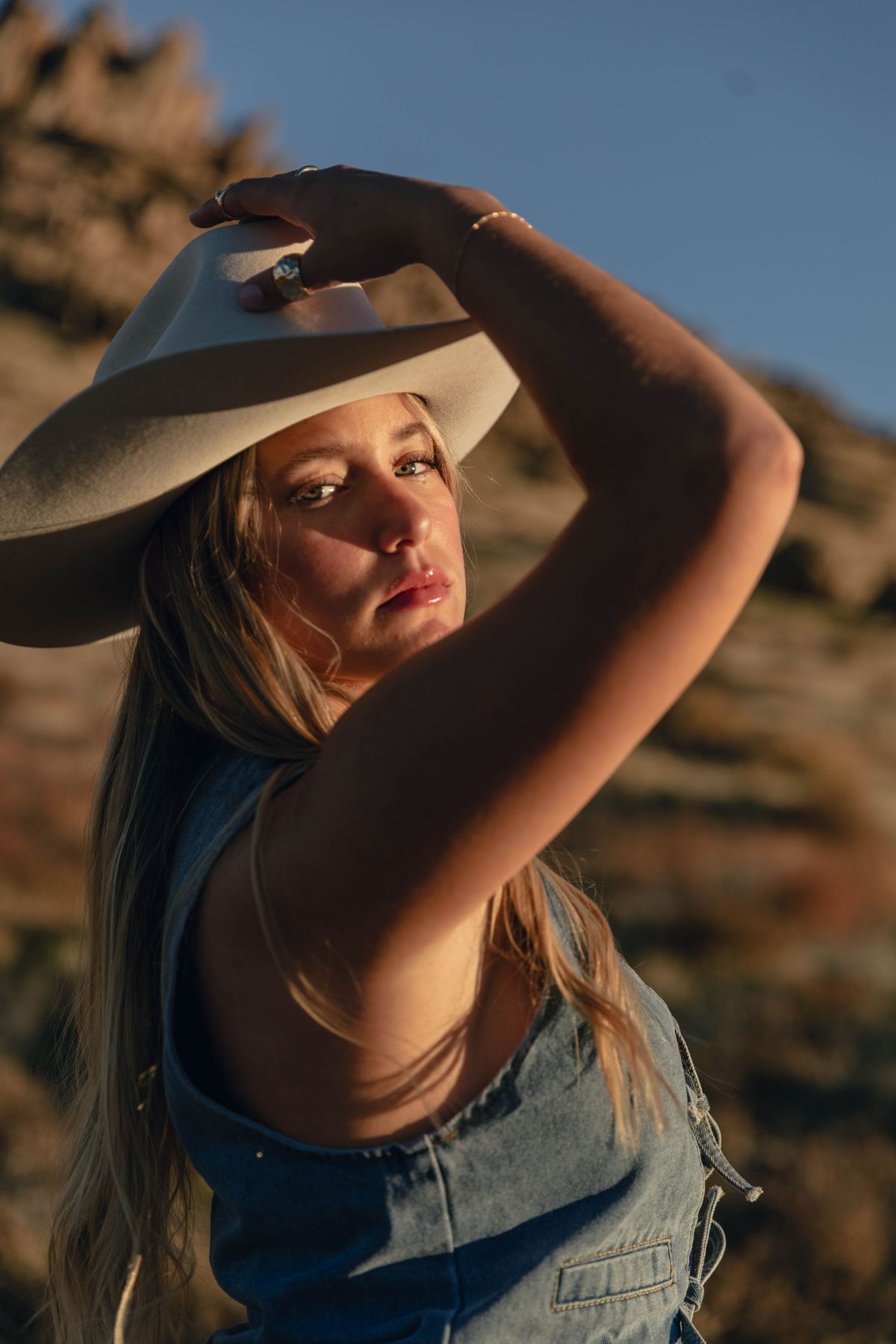 A senior portrait in a straw hat, backlit by the sun