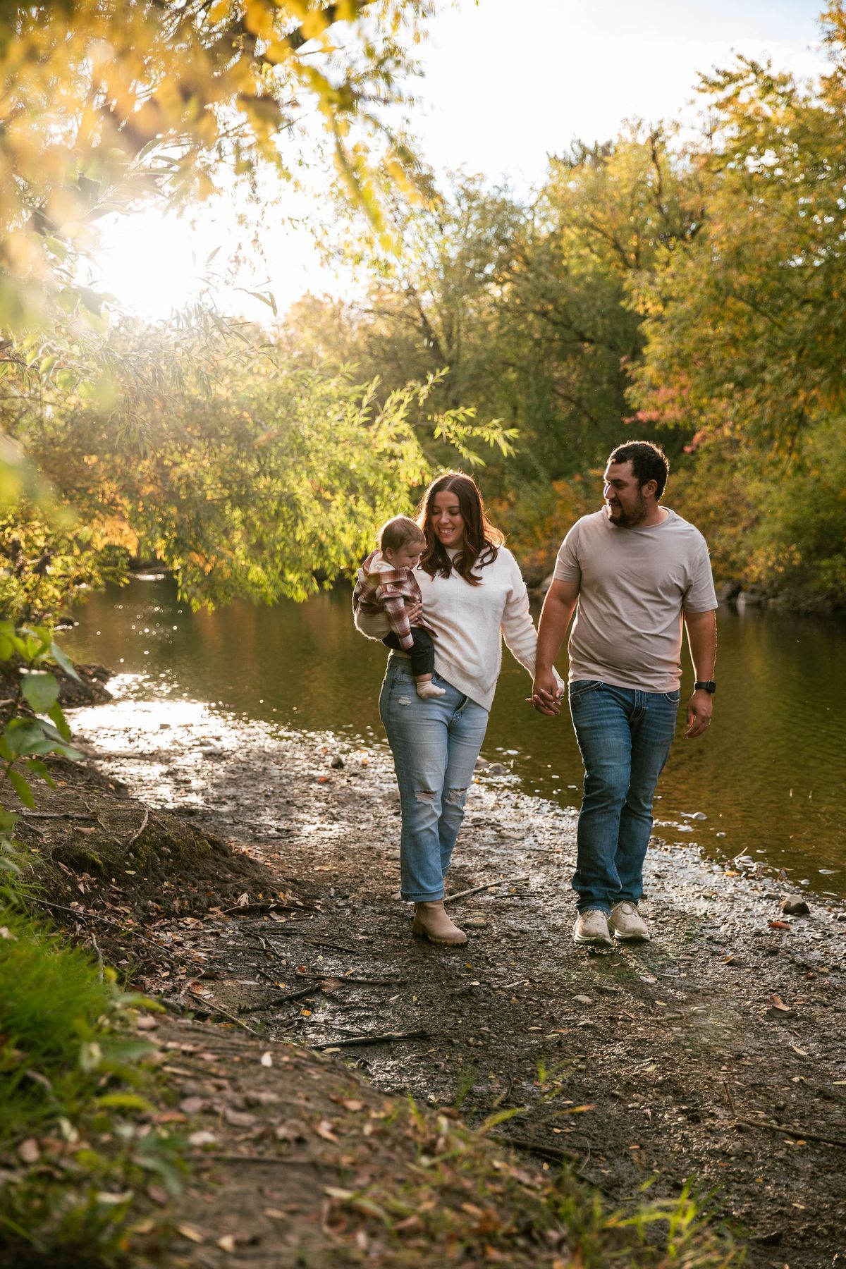 A family walking together beside a river in golden autumn light