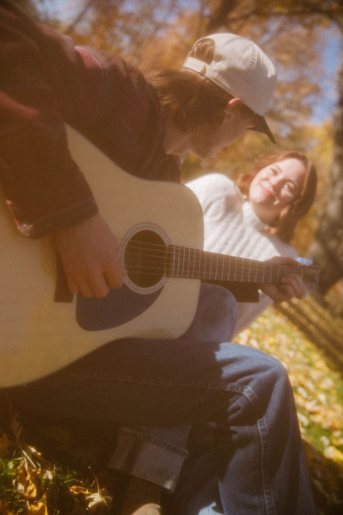 A couple with a guitar in golden autumn light