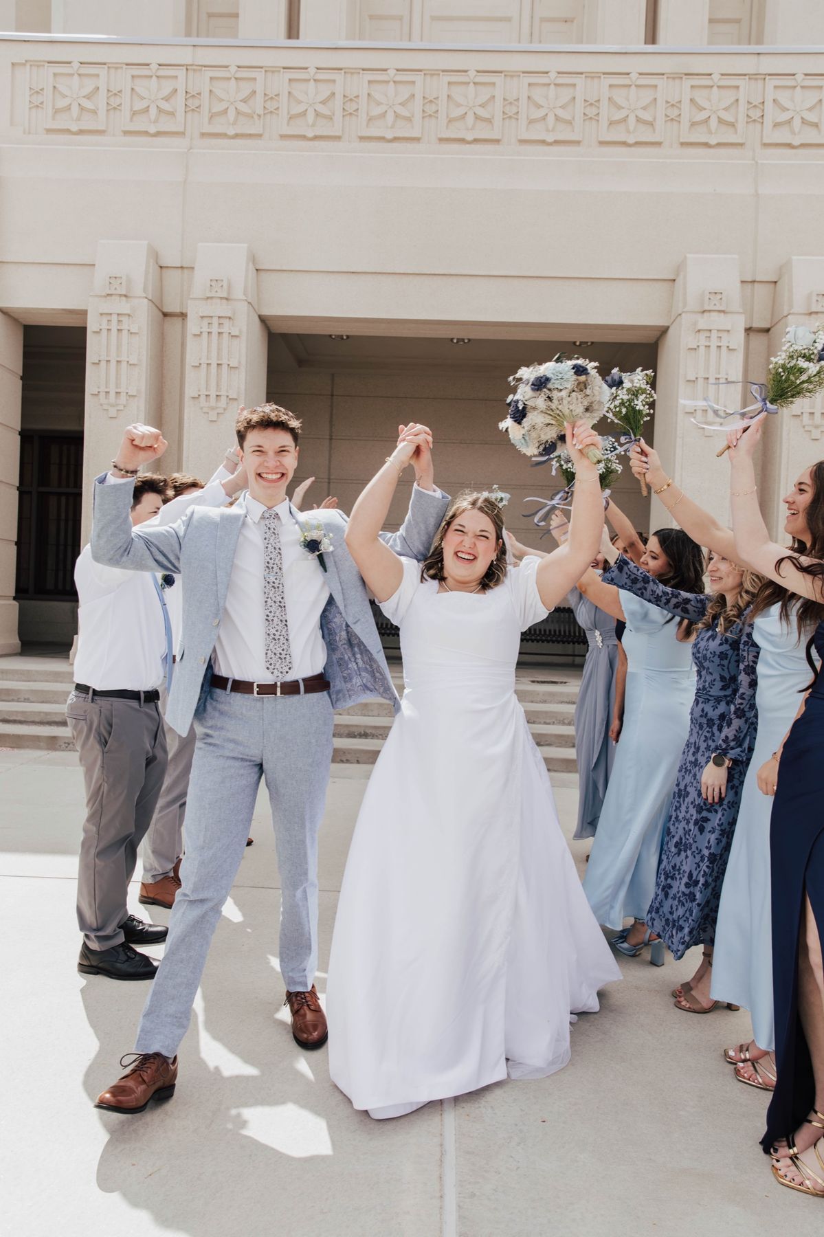 The wedding party cheering on the steps